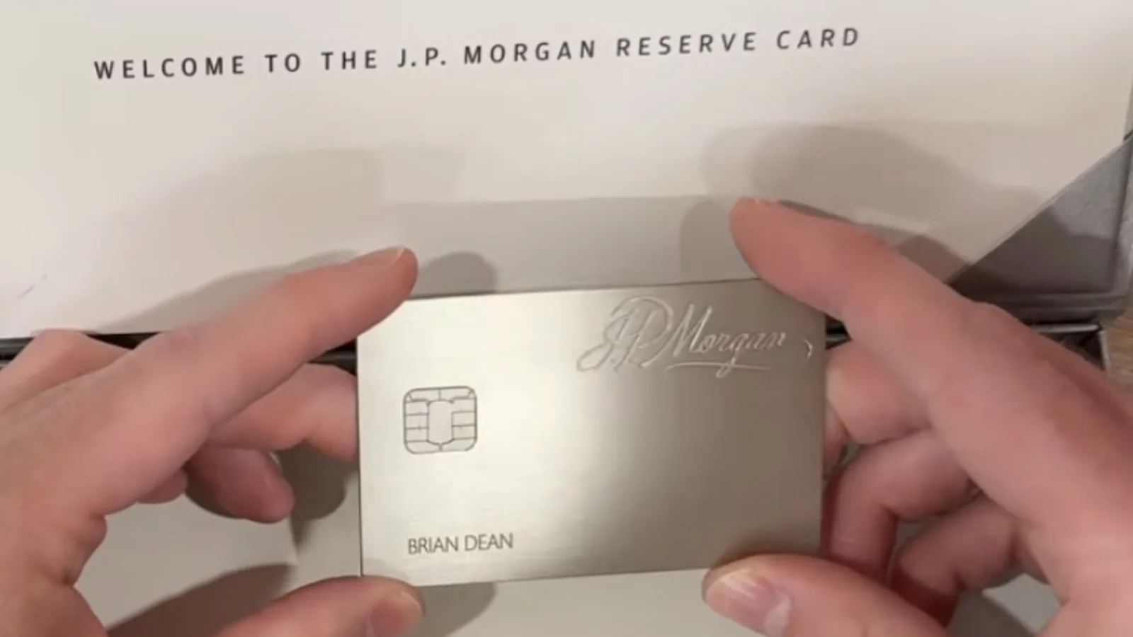 J.P. Morgan Reserve metal credit card held in both hands with welcome card insert reading 'Welcome to the J.P. Morgan Reserve Card', 2026 unboxing photo